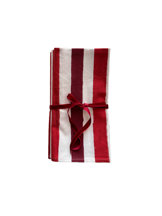 Red striped block printed cotton napkins folded and tied with a red velvet ribbon