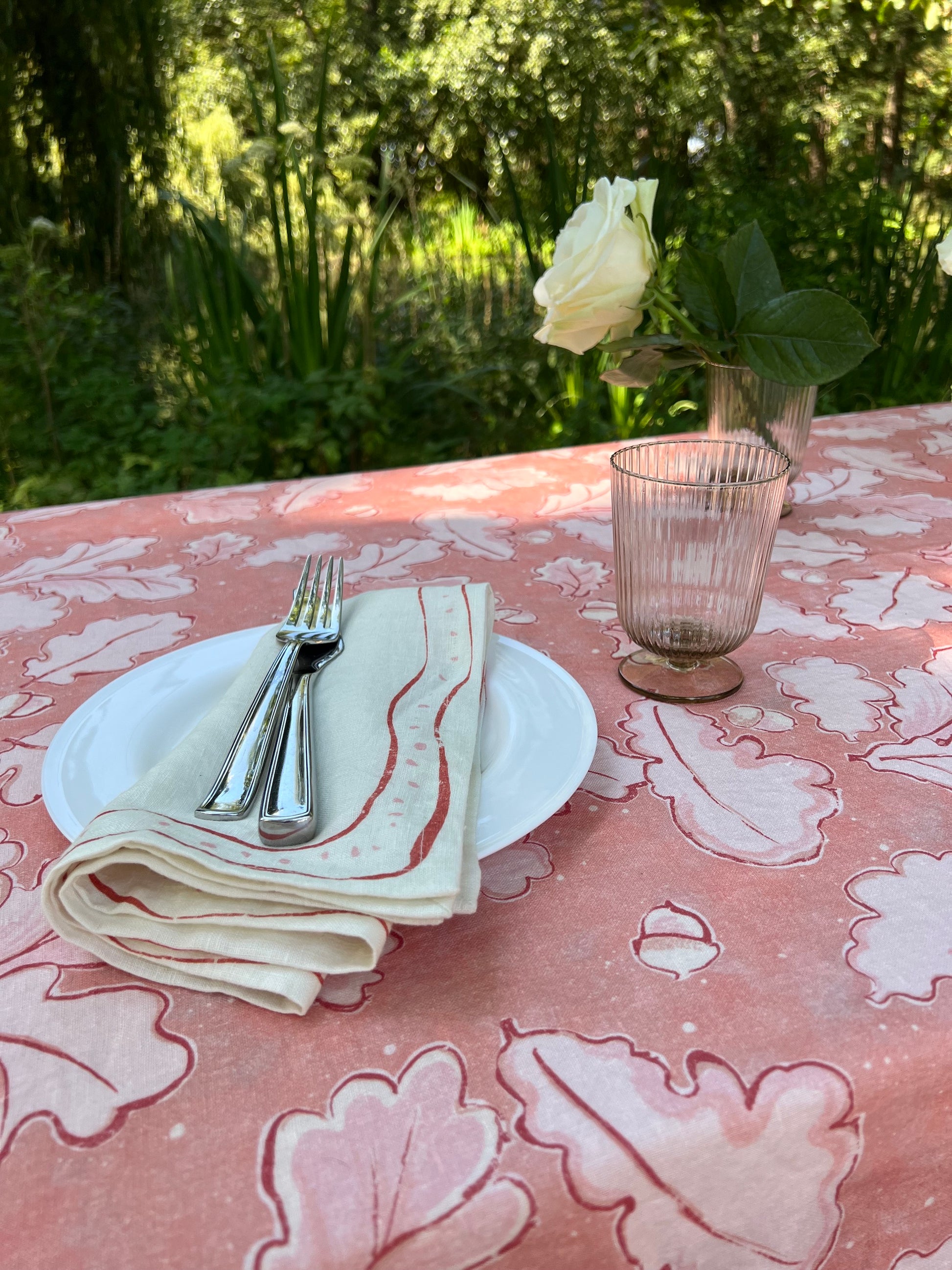 Beautiful Grace Tablecloth in different shades of pink, showcasing oak leaves and acorns across the cloth. 100% Linen.